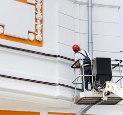 Muž pracuje na nové omítce historického domu